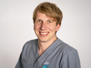 Dr. Gregor Eiling lächelt, trägt graublaue Kleidung.